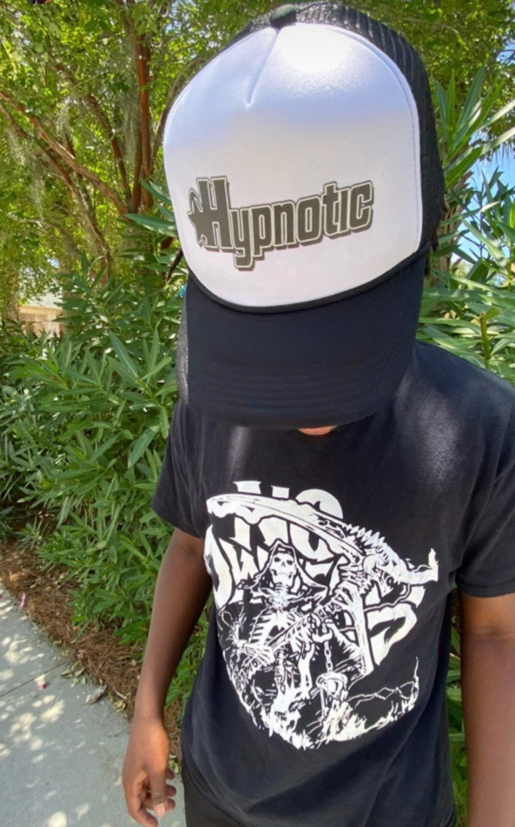 Person (Nimstarr) wearing Hypnotic Clothing printed logo trucker hat, photographed inside a car.