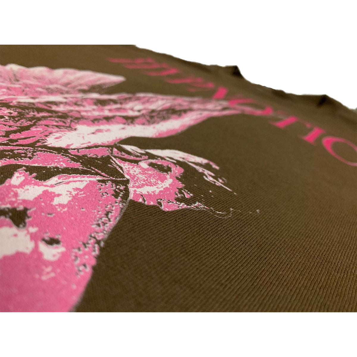 Close-up of distressed pink angel graphic on Hypnotic Clothing ‘Angel’ tee showing print texture on brown cotton.
