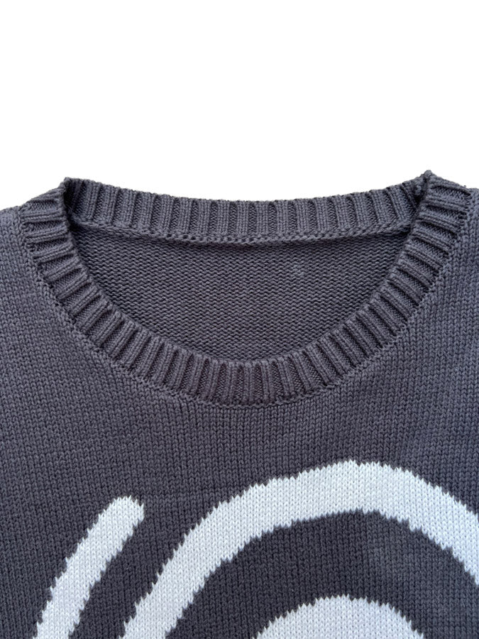 Close-up of Hypnotic Clothing ‘Lost in the Matrix’ sweater collar and upper spiral knit pattern in white on charcoal fabric.